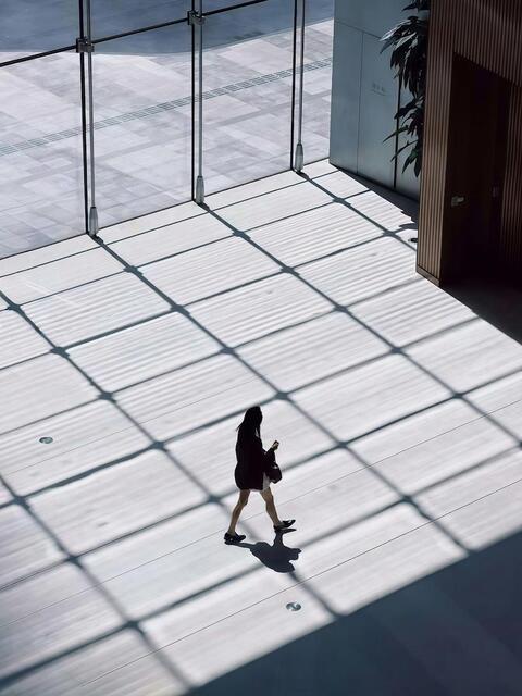 Woman walking with windows in the background